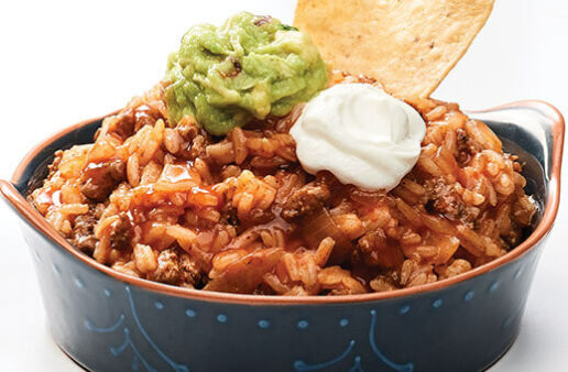 Hearty enchilada dip with jasmine rice, guacamole, sour cream and tortilla chips