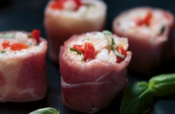 Italian Sushi with arborio rice and red bell peppers rolled in prosciutto
