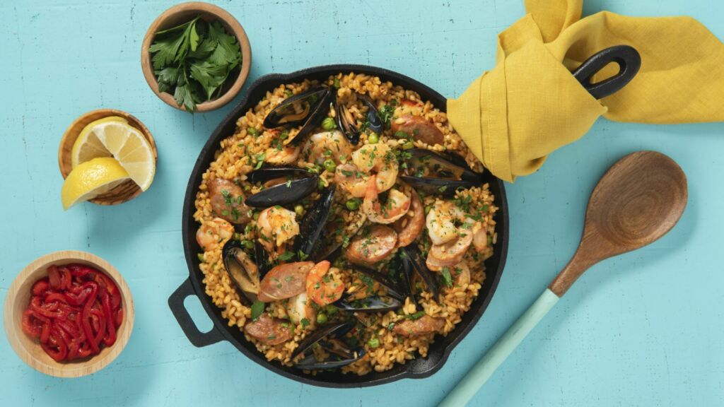 Traditional-Paella-Dish-with-Red-Bell-Peppers-Lime-Wedges-Chorizo-Shrimp-Mussels-and-Fresh-Parsley